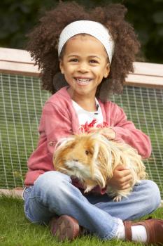 Young girl in garden holding guinea pig