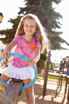 Young Girl Having Fun On Seesaw In Playground
