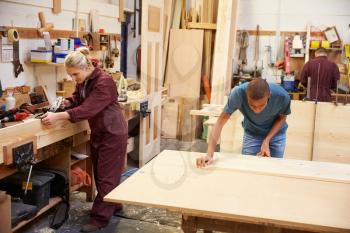 Staff Working In Busy Carpentry Workshop