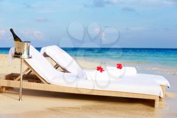 Loungers At Edge Of Tropical Sea With Champagne Bucket