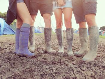 Close Up Of Friends In Wellington Boots Walking To Festival