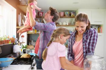 Family Cooking Meal In Kitchen Together