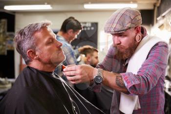 Male Barber Giving Client Shave In Shop