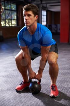 Man In Gym Exercising With Kettle Bell Weight