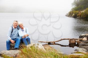 Senior couple sitting together by a lake