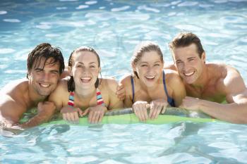 Portrait Of Group Of Friends Relaxing In Swimming Pool