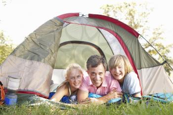 Father With Teenage Children On Camping Holiday In Countryside