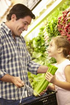 Father and daughter buying vegetables in supermarket