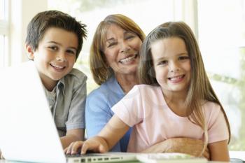 Hispanic Grandmother Using Laptop With Grandchildren