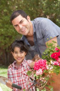 Hispanic Father And Son Working In Garden Tidying Pots