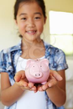 Young girl holding piggybank