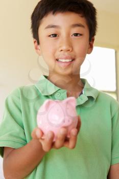 Young boy holding piggybank