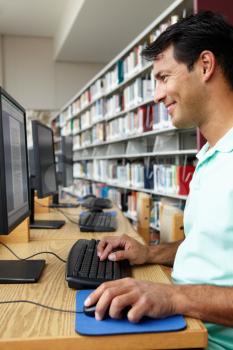 Man working on computer in library