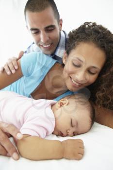 Parents With Sleeping Baby Daughter At Home