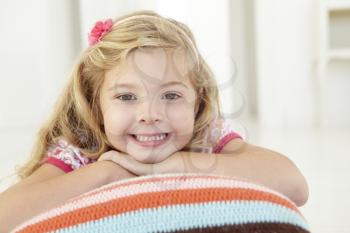 Young Girl Relaxing On Cushion On Floor In Bedroom