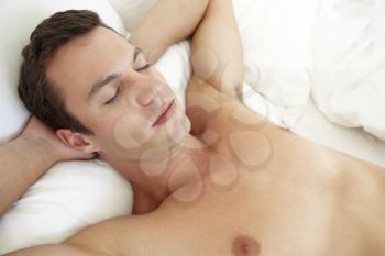 Young Bare Chested Man Relaxing On Bed