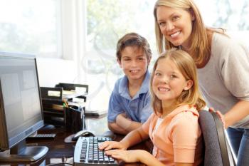 Mother and children using computer at home