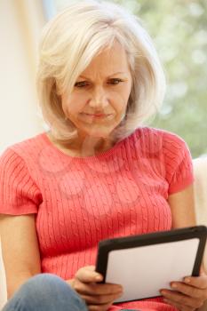 Mid age woman using tablet at home