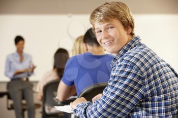 Teenage boy in class smiling to camera
