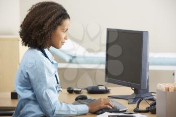 Young female Doctor working on computer at desk