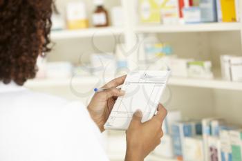 UK Female nurse in pharmacy with prescription
