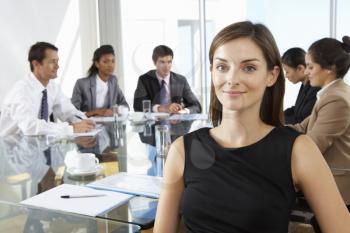Businesswoman Sitting Around Boardroom Table With Colleagues