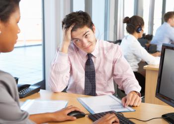 Stressed Employee Working In Busy Office