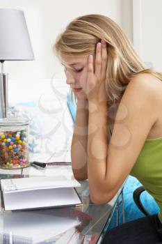 Unhappy Teenage Girl Writing In Diary