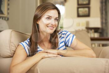 Woman Sitting On Sofa At Home Watching TV
