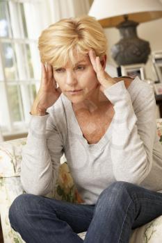 Unhappy Mature Woman Sitting On Sofa At Home