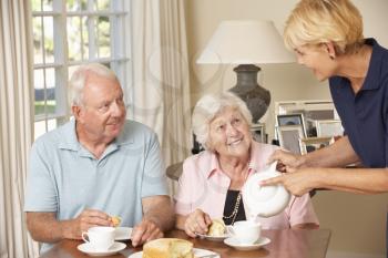 Senior Couple Enjoying Afternoon Tea Together At Home With Home Help