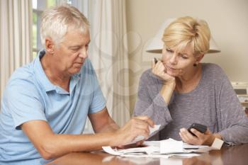 Worried Mature Couple Checking Finances And Going Through Bills Together