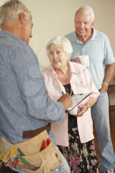 Repairman Giving Senior Couple Estimate For Repair