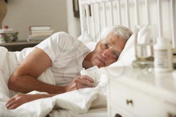 Sick Senior Man In Bed At Home