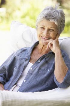 Portrait Of Happy Senior Woman Sitting On Sofa