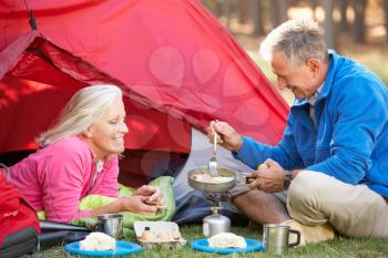 Senior Couple Cooking Breakfast On Camping Holiday