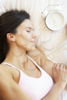 Woman Sleeping In Bed With Alarm Clock