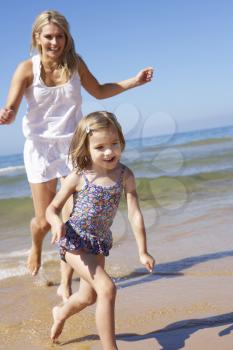 Mother Chasing Daughter Along Beach