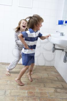 Boy And Girl In Bathroom Brushing Teeth