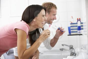 Couple In Bathroom Brushing Teeth