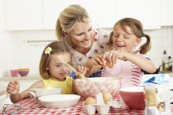 Mother And Two Girls Baking In Kitchen