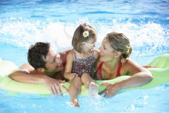 Family On Holiday In Swimming Pool