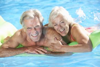 Senior Couple On Holiday In Swimming Pool
