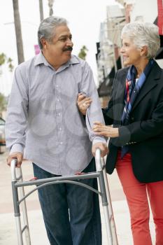 Wife Helping Senior Husband To Use Walking Frame