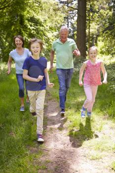 Grandparents With Grandchildren Running Through Countryside