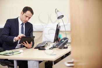 Male Consultant Using Digital Tablet At Desk In Office