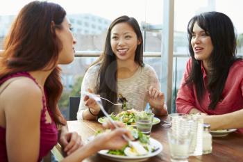 Three Female Friends Enjoying Lunch At Rooftop Restaurant