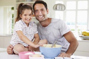Father And Daughter Baking Cake In Kitchen