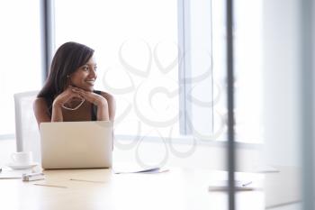 Businesswoman Working On Laptop At Boardroom Table