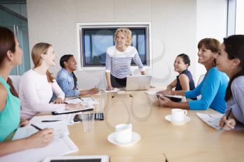 Group Of Businesswomen Meeting Around Boardroom Table